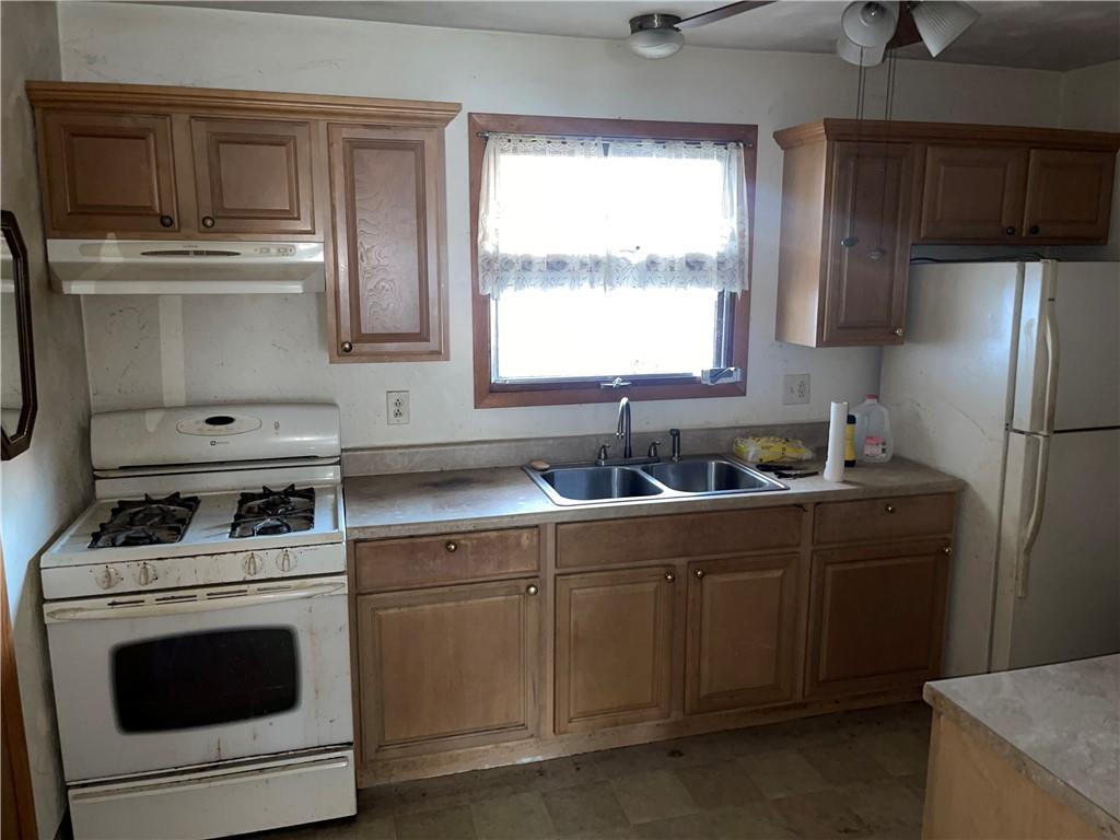 38 3rd Street Scottdale, PA 15683 - Photo 8 of 17 a kitchen with a sink stove and refrigerator