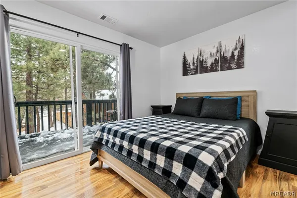 a bedroom with bed and wooden floor