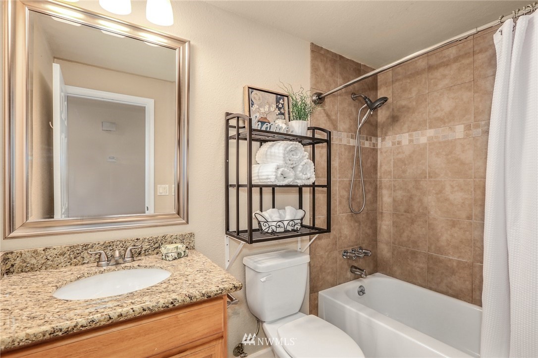 22703 2nd Place West Bothell, WA 98021 - Photo 19 of 23 a bathroom with a granite countertop sink toilet a mirror and shower