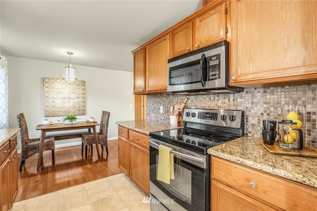 22703 2nd Place West Bothell, WA 98021 - Photo 10 of 23 a kitchen with stainless steel appliances granite countertop a stove a sink and a microwave