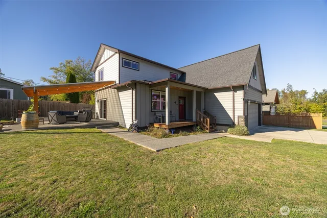 a view of a house with floor to ceiling windows and a table and chairs