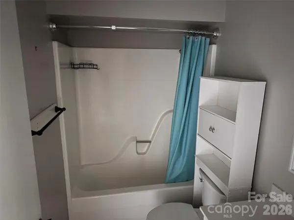 a bathroom with a granite countertop shower and a toilet
