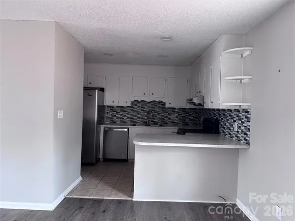 a kitchen with a stove and white cabinets