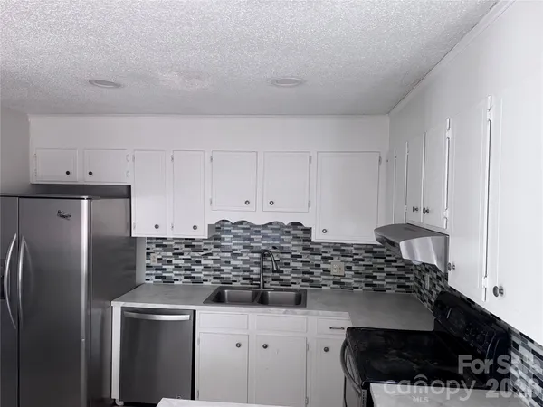 a kitchen with stainless steel appliances kitchen island granite countertop a refrigerator and a stove