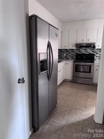 a kitchen with stainless steel appliances granite countertop a stove a refrigerator and a cabinets