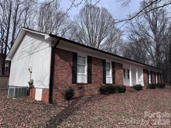 a view of a house with a yard and pathway