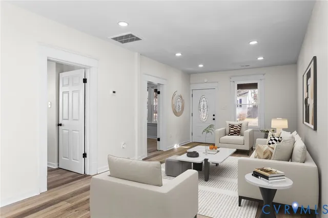 a living room with furniture and wooden floor