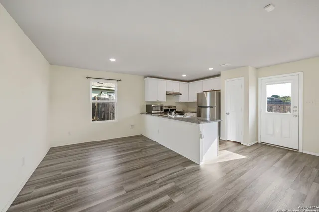 a view of kitchen with wooden floor and electronic appliances