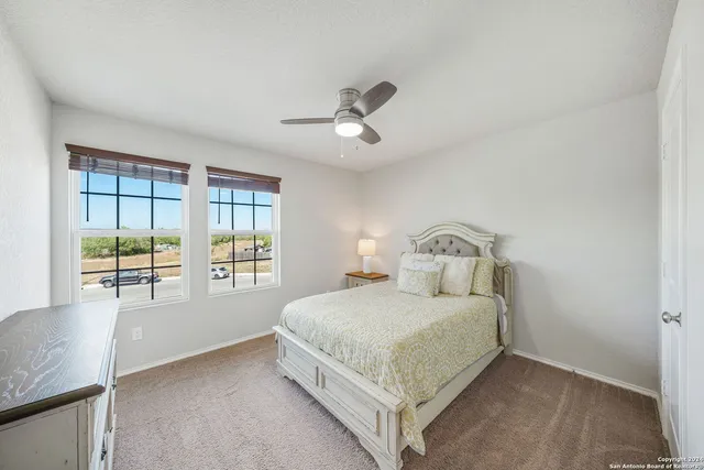 a bedroom with a bed next to a window with a chandelier