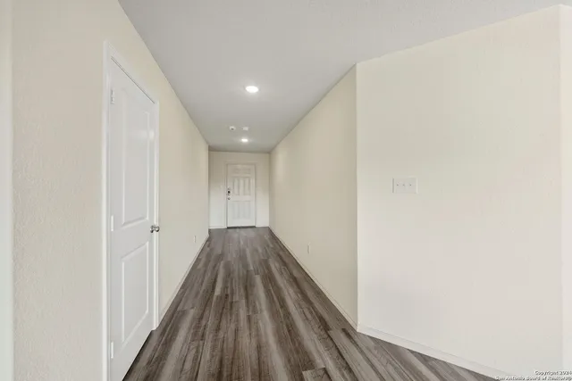 a view of a hallway with wooden floor