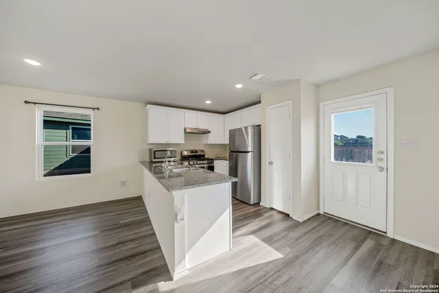a kitchen with stainless steel appliances a refrigerator and a stove top oven