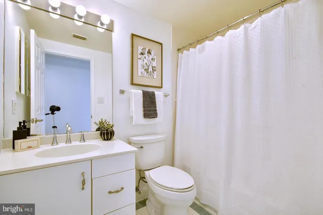 a bathroom with a sink mirror vanity and toilet