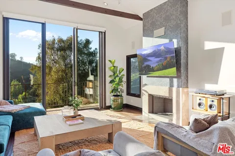 a living room with fireplace furniture and a large window