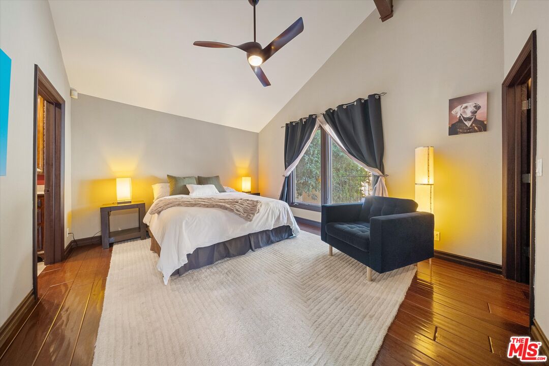 7223 Sycamore Trail Los Angeles, CA 90068 - Photo 21 of 62 a bedroom with a bed lamps and wooden floor