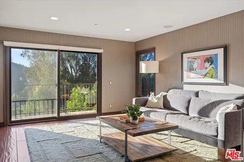 a balcony with wooden floor and yard in the back