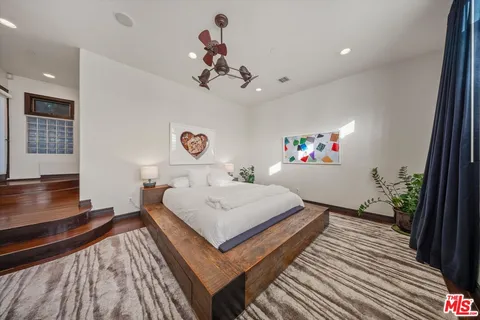 a bedroom with a bed and a potted plant