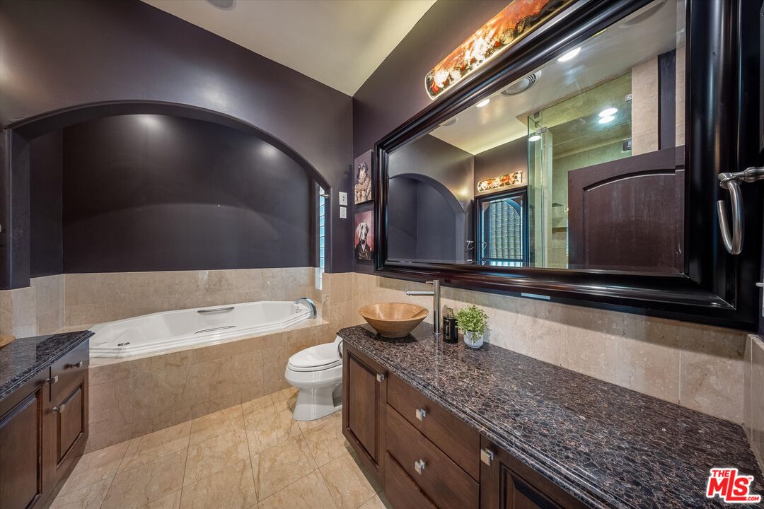 7223 Sycamore Trail Los Angeles, CA 90068 - Photo 43 of 62 a bathroom with a granite countertop bathtub sink vanity mirror and toilet