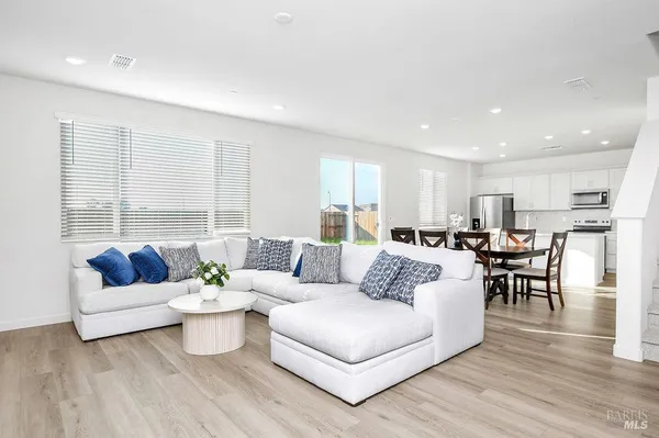 a living room with furniture and view of kitchen