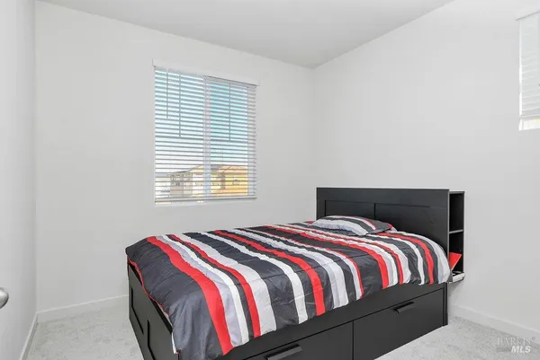 a bed sitting in a bedroom next to a window