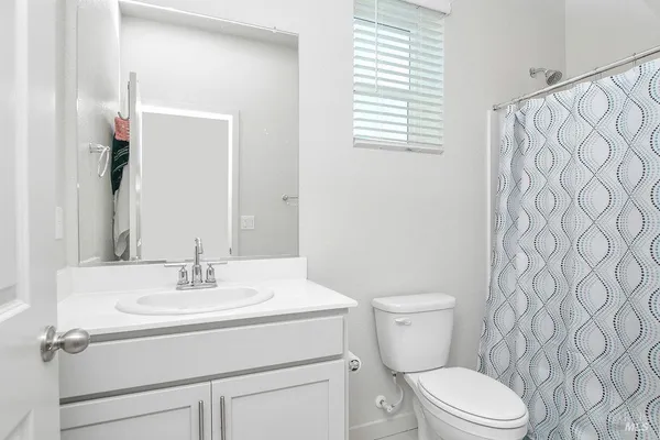 a bathroom with a sink a toilet and a mirror