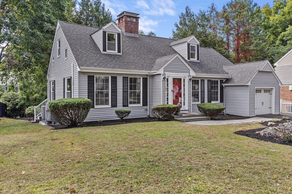 a view of a house with a yard and a large tree