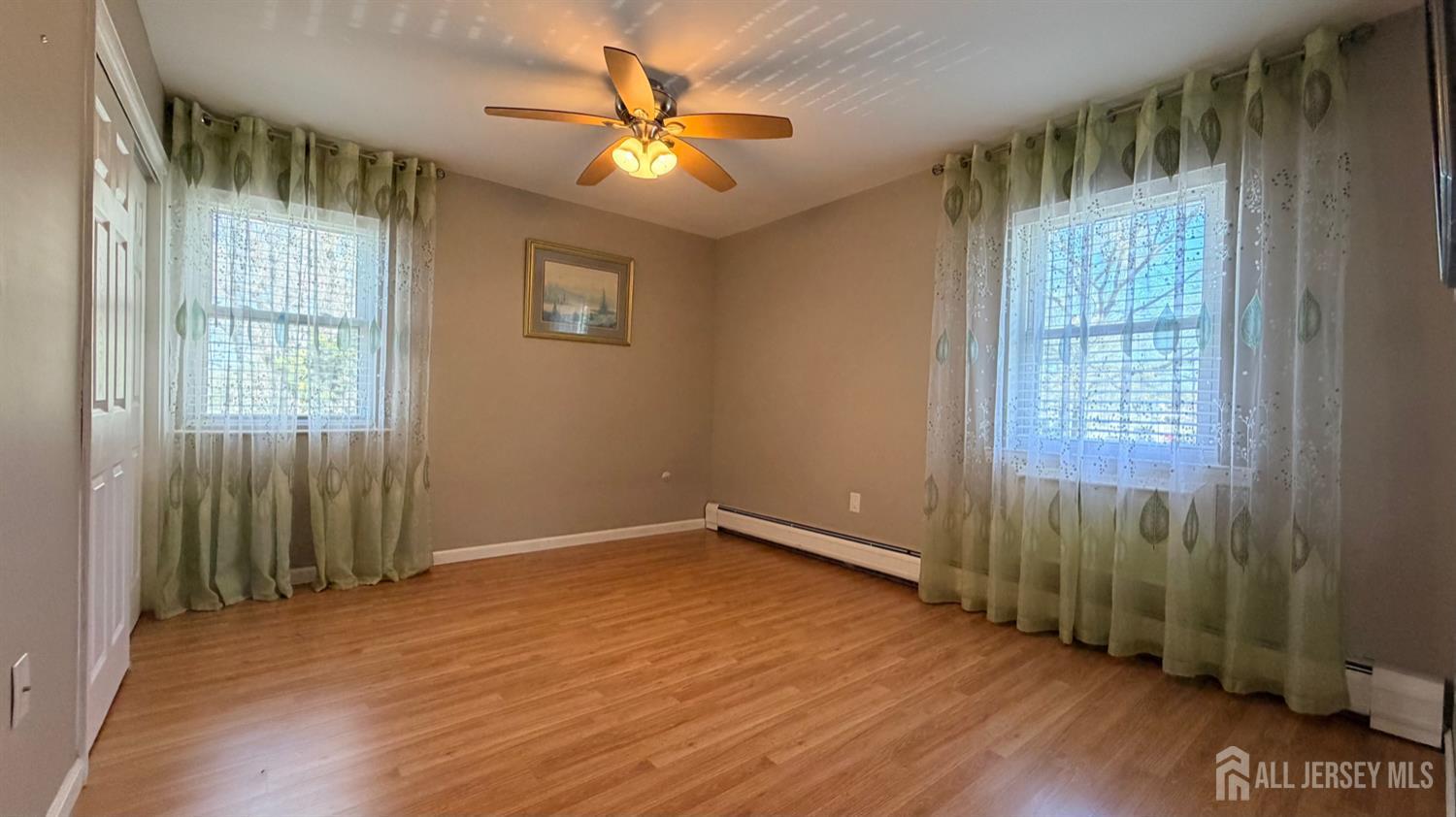 363 Cranbury Road, Unit D16 East Brunswick, NJ 08816 - Photo 14 of 32 an empty room with wooden floor and windows
