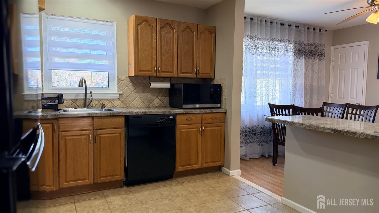 363 Cranbury Road, Unit D16 East Brunswick, NJ 08816 - Photo 29 of 32 a kitchen with stainless steel appliances granite countertop a sink stove and cabinets