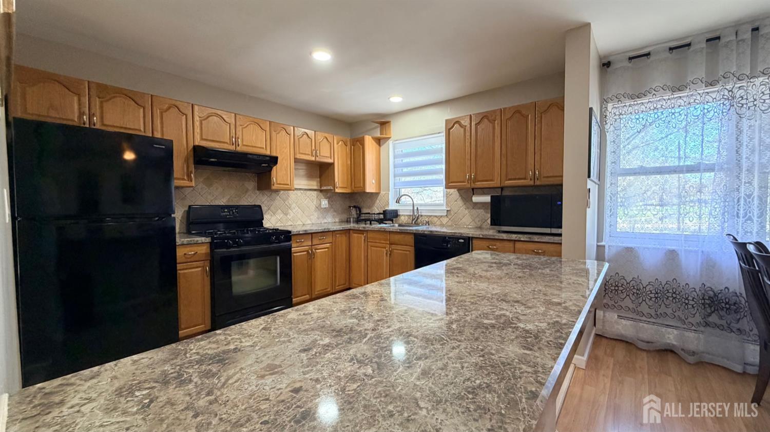 363 Cranbury Road, Unit D16 East Brunswick, NJ 08816 - Photo 8 of 32 a kitchen with kitchen island granite countertop a refrigerator stove top oven and sink
