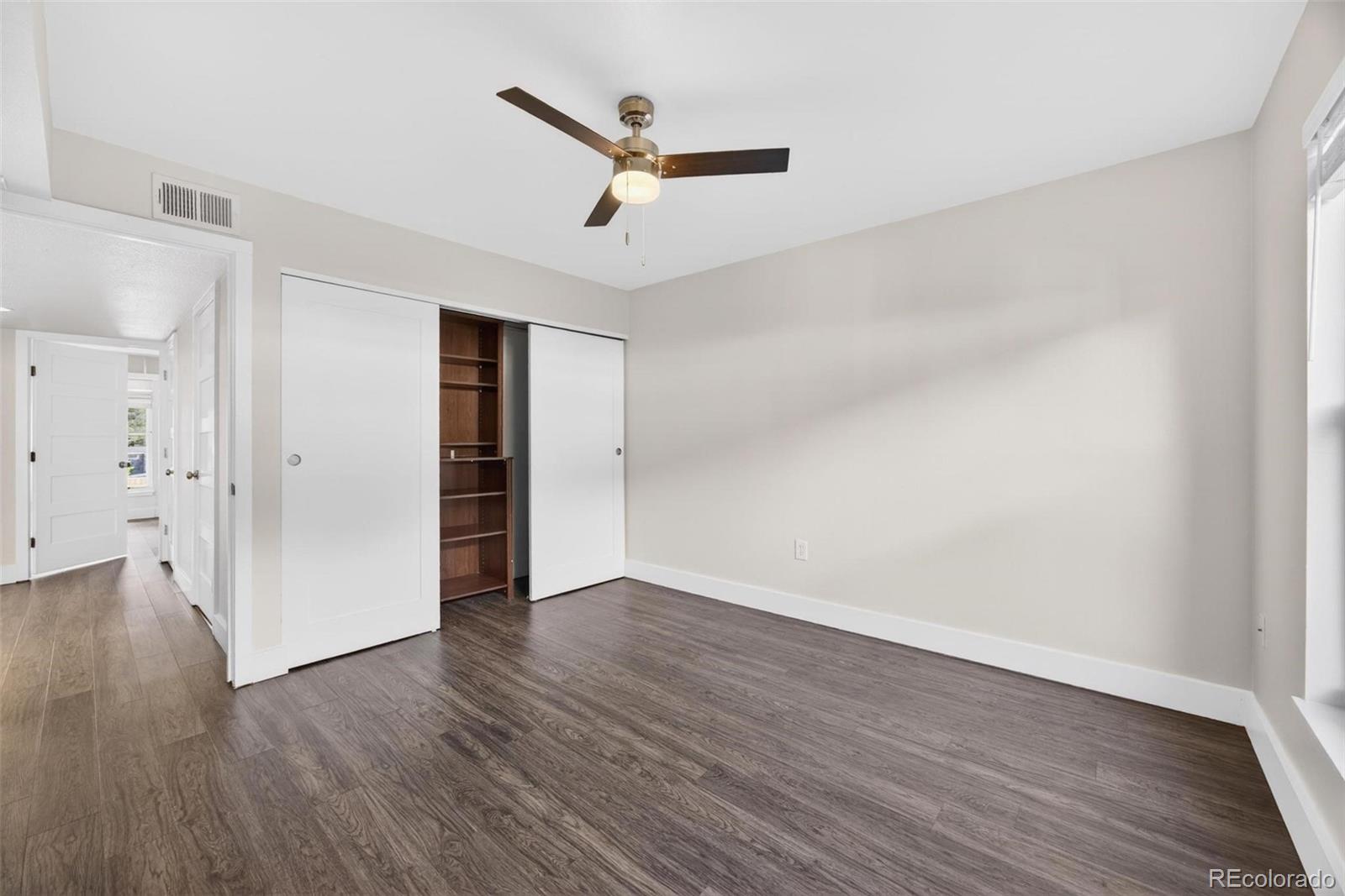 1150 Inca Street, Unit 46 Denver, CO 80204 - Photo 17 of 45 an empty room with wooden floor and a ceiling fan