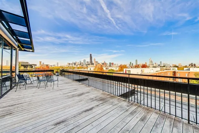 a view of a balcony with chairs and wooden floor