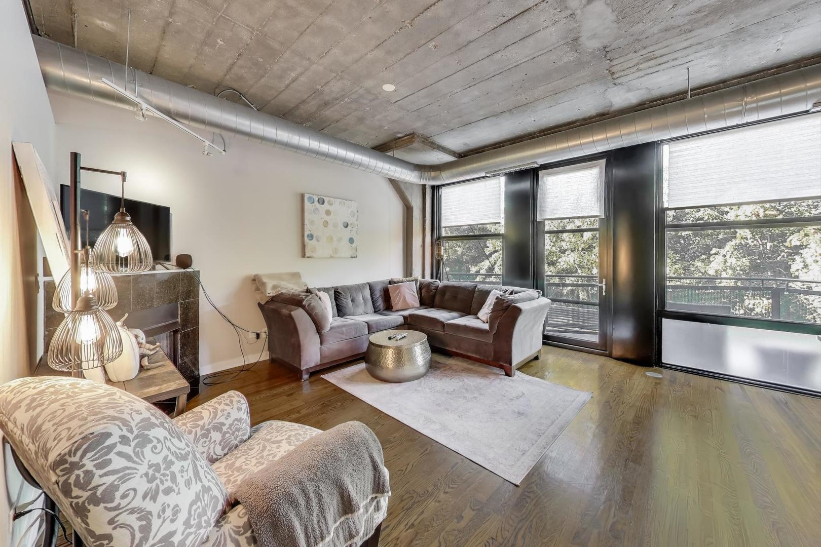 1001 West 15th Street, Unit 241 Chicago, IL 60608 - Photo 5 of 41 a living room with furniture and a floor to ceiling window
