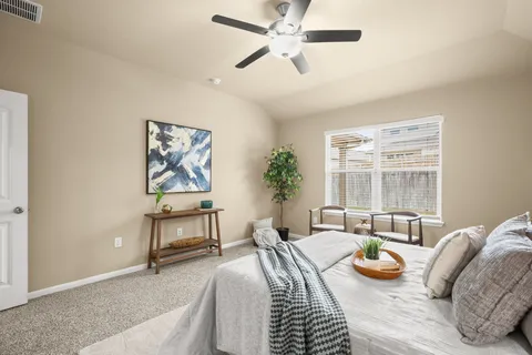 a spacious bedroom with a bed a couch and a window