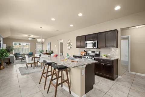 a kitchen with appliances a table chairs and a refrigerator