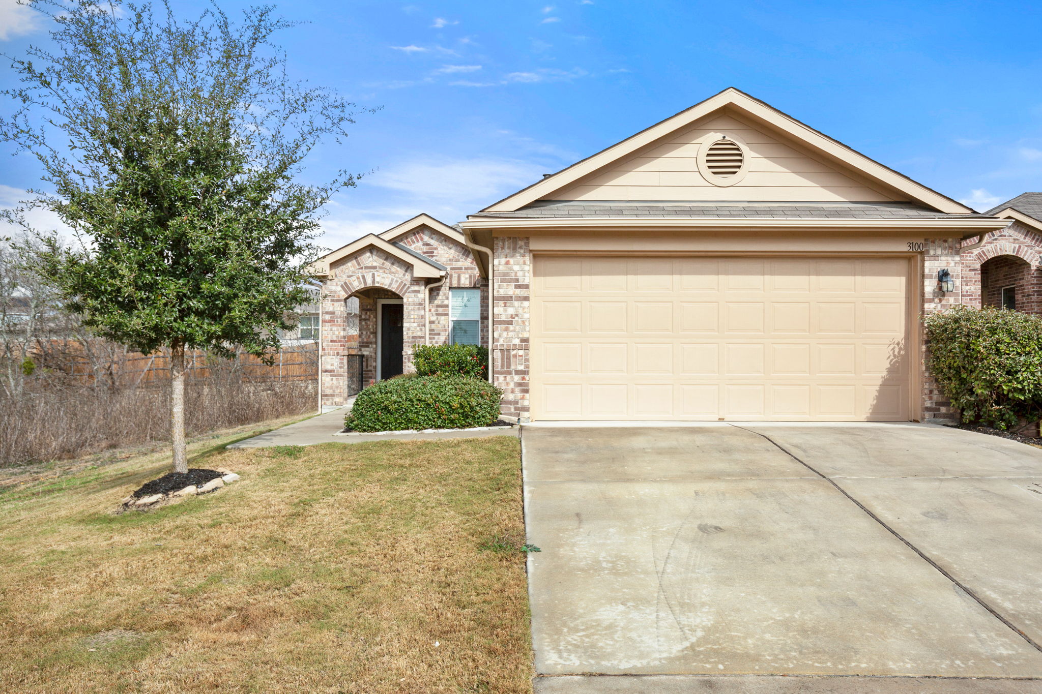 3100 Crystal Bend Drive Pflugerville, TX 78660 - Photo 9 of 32 Single story home featuring driveway, a front lawn, an attached garage, and stone siding