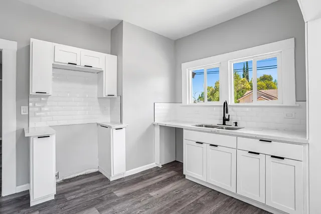a kitchen with a sink cabinets and wooden floor