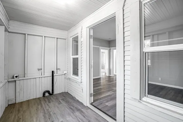 a view of a hallway with wooden floor and staircase