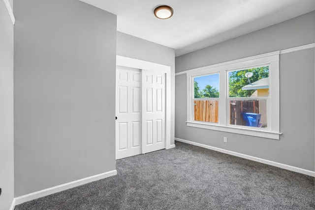 an empty room with windows and closet