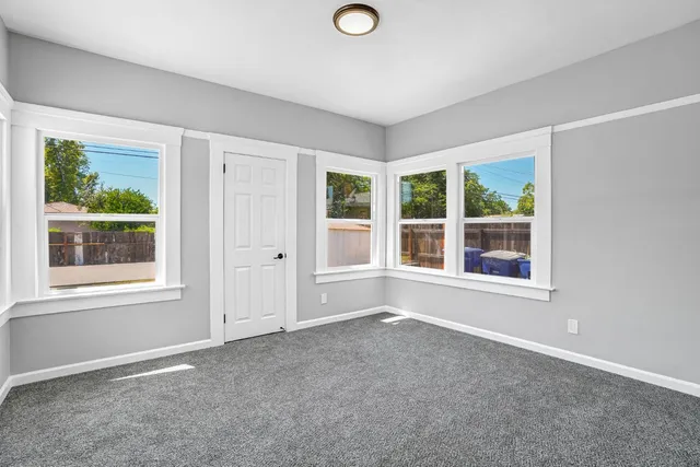 an empty room with windows and closet