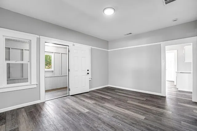 a view of empty room with wooden floor and entryway