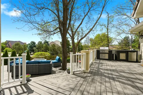 a view of a patio with table and chairs with wooden floor and fence