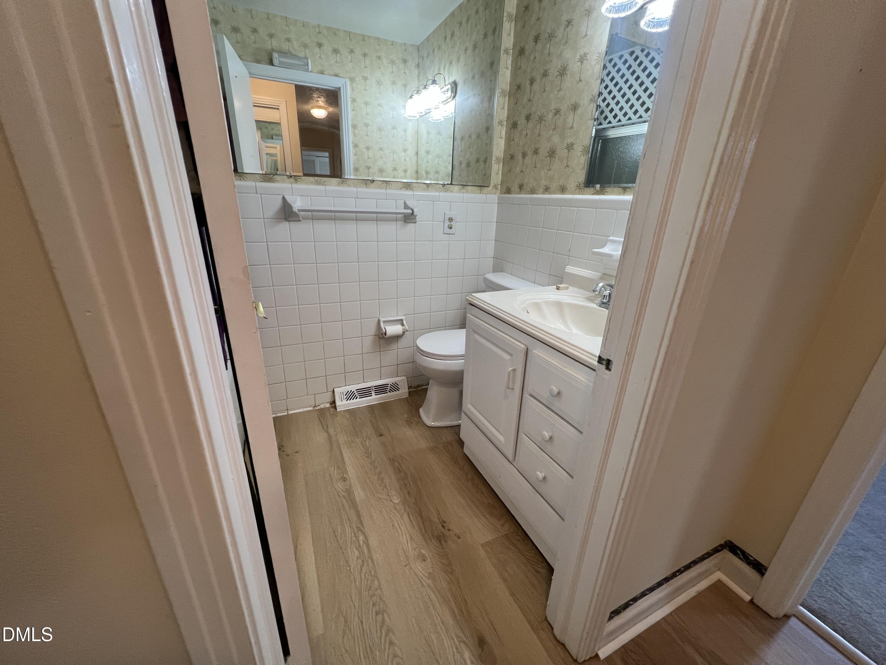 66 Allensville Road Roxboro, NC 27573 - Photo 30 of 52 a bathroom with a sink a toilet a mirror and vanity