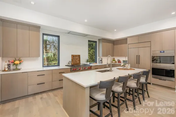 a kitchen with appliances a sink and chairs