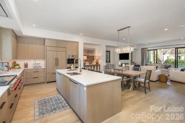 a large kitchen with kitchen island a sink table and chairs