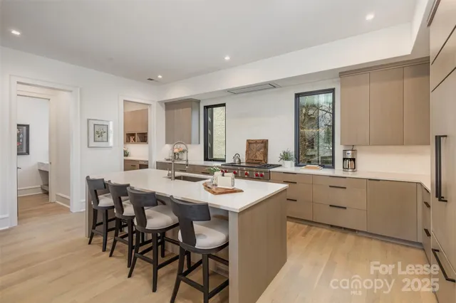 a kitchen with white cabinets and sink