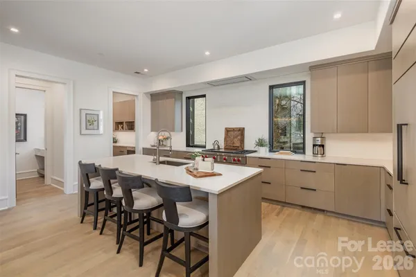 a kitchen with white cabinets and sink