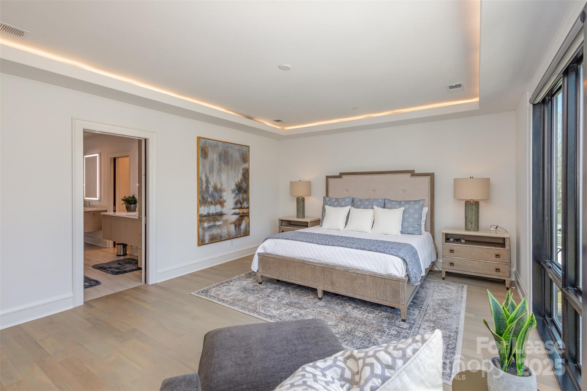 616 Queens Road Charlotte, NC 28204 - Photo 24 of 36 a spacious bedroom with a bed a table and painting