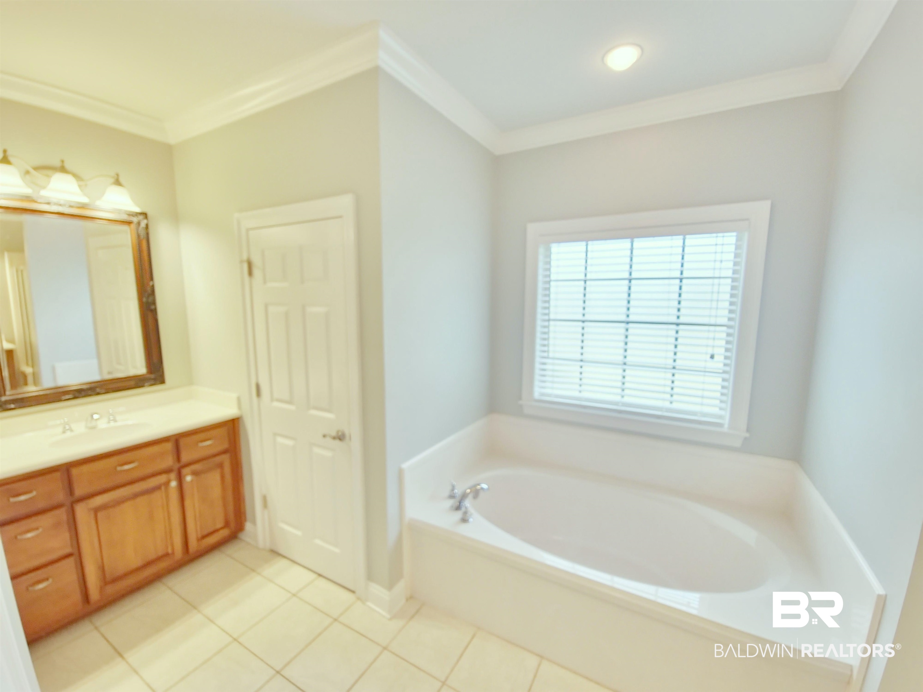 306 South Tee Drive Fairhope, AL 36532 - Photo 18 of 37 Bathroom with tile patterned flooring, a washtub, ornamental molding, and vanity
