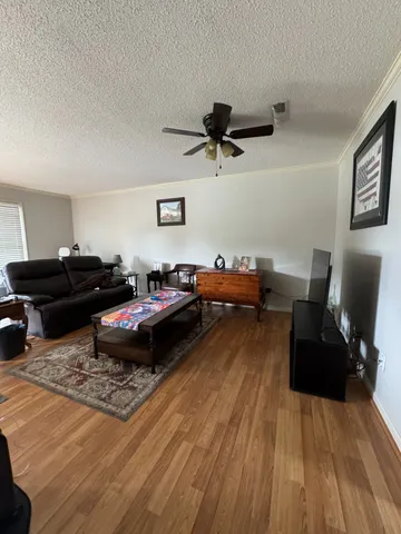 a living room with furniture and a wooden floor