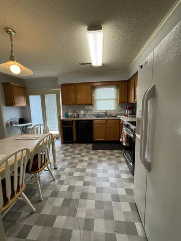 a kitchen with stainless steel appliances a stove a sink a refrigerator and a refrigerator