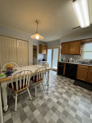 a kitchen with stainless steel appliances a stove a sink a dining table and chairs